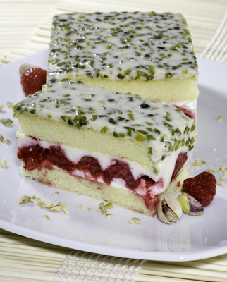 Ölz Himbeer-Pistazien-Schnitten mit cremiger Himbeerfüllung, Pistaziencreme und frischen Himbeeren auf lockerem Kuchenboden