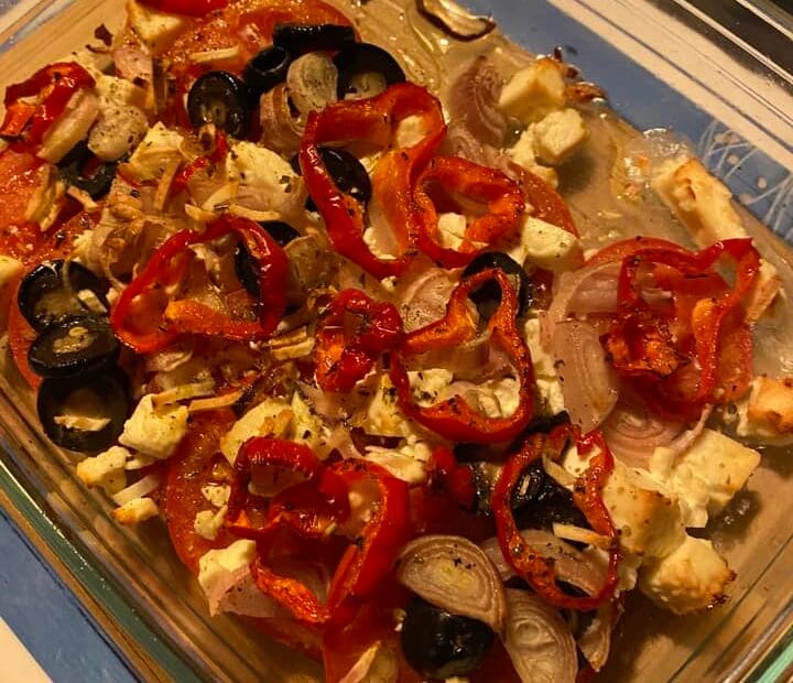 Gebackener Schafskäse mit Olivenöl und Kräutern auf einem Teller