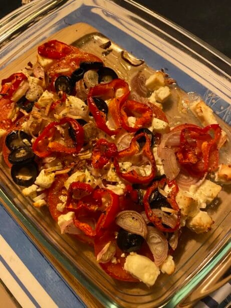 Gebackener Schafskäse mit Olivenöl und Kräutern auf einem Teller